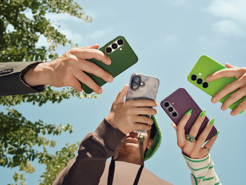 Flere personer holder smartphones op mod blå himmel